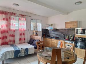 a kitchen with a bed and a table in a room at Location chambres chez Zam in Mamoudzou