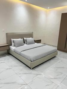 a bedroom with a large bed with white sheets and pillows at La Casa Residence in Dakar