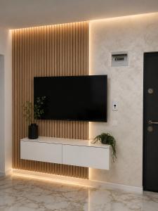 a living room with a television on a wall at LWS Apartments in Dej