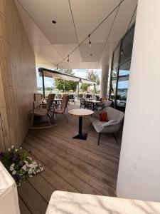 a patio with a table and chairs and tables and windows at Nad zatoką Ukiel apartamenty przy jeziorze in Olsztyn
