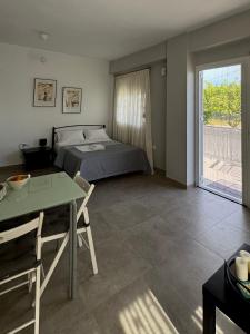 a bedroom with a bed and a table and a window at Nefeli's apartment in Vonitsa