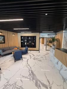 a lobby with a marble floor with couches and chairs at Nad zatoką Ukiel apartamenty przy jeziorze in Olsztyn