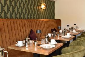 a row of wooden tables in a restaurant with chairs at Lipmanns Boutique-Hotel in Cochem