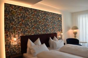a bedroom with two beds and a floral wall at Lipmanns Boutique-Hotel in Cochem +3 photos