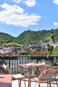 a table and chairs on a balcony with a view of a city at Lipmanns Boutique-Hotel in Cochem