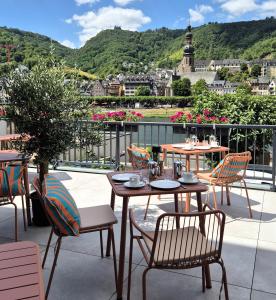 a patio with tables and chairs and a view of a city at Lipmanns Boutique-Hotel in Cochem