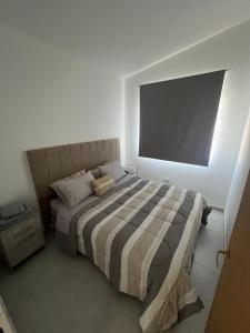 a bedroom with a bed with a television on the wall at Austral Premium in Comodoro Rivadavia
