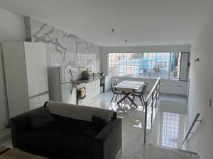 a living room with a couch and a table in a kitchen at Austral Premium in Comodoro Rivadavia