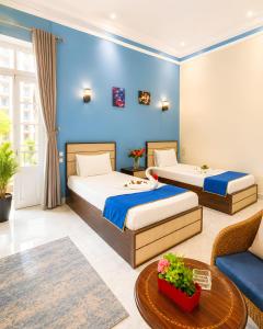 a bedroom with two beds and a blue wall at Royal Hostgram and Suites in Cairo