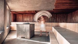 Eine Frau steht in einem Raum mit einer Badewanne. in der Unterkunft Panoramahotel Watles in Mals im Vinschgau + 75 Fotos