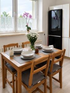 a dining room table with chairs and plates and flowers at Aura Poręba Żegoty in Poręba Żegoty