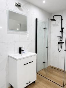 a white bathroom with a sink and a shower at Aura Poręba Żegoty in Poręba Żegoty +24 photos