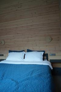 a bed in a room with a wooden wall at Chalet 1391 in Ryskulovo