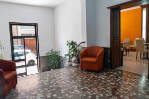 a waiting room with a chair and a table with a car at Albergo San Lorenzo in Grosseto +4 photos