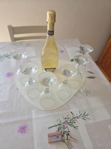 a bottle of wine and wine glasses on a table at Casa Nanà Beach in Lido Adriano