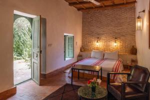 a bedroom with a bed and a chair and a table at Sel d Ailleurs, Ouirgan - adults only in Ouirgane +71 photos