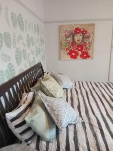 a bed with pillows and a painting on the wall at Feather Foot Self catering Accommodation in Heidelberg