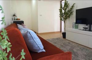 a person laying on a couch in a living room at condoTip in Loei