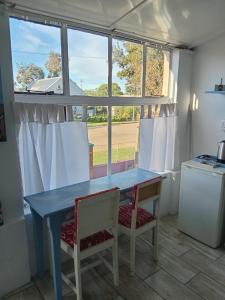 a blue table and chairs in a kitchen with a window at Feather Foot Self catering Accommodation in Heidelberg +15 photos