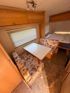 a small room with two beds and a table at Karavan Hrdlička in Čím +4 photos