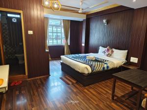 a hotel room with a bed and a table at Hotel The Dzong ! Gangtok in Gangtok +4 photos