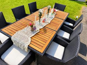 a wooden table with chairs around it with flowers on it at Aura Poręba Żegoty in Poręba Żegoty