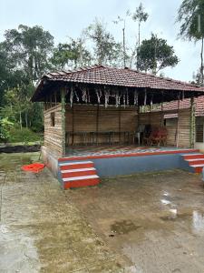 a small house with a roof on top of it at Gopetown Homestay in Mudigere