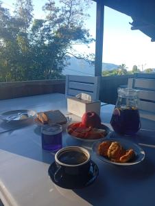 ein Tisch mit Tellern mit Essen und einer Schüssel mit Flüssigkeit in der Unterkunft Benabilla Cottage in Gisi