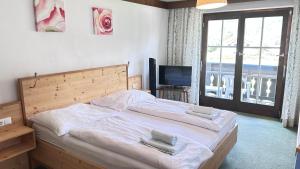 a bedroom with a bed with two towels on it at Appartementhaus Huber in Abersee
