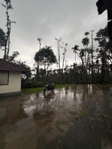 a person is standing in a flooded street at Gopetown Homestay in Mudigere