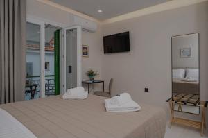 a bedroom with a bed with two towels on it at Dimitra Suites in Pythagoreio