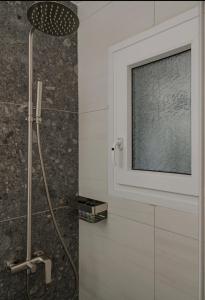 a bathroom with a shower with a window at Dimitra Suites in Pythagoreio +5 photos