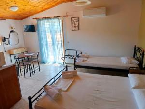 a room with two beds and a table and chairs at Hector's Studios in Alikanas +120 photos