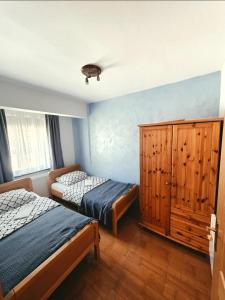 a bedroom with two beds and a wooden cabinet at Apartment Love in Vlasic