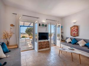 a living room with a couch and a television at Cycladic home in Paros in Kampos Paros