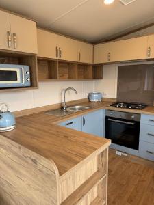 a kitchen with a wooden counter top and a microwave at Luxury Lodge in Beverley