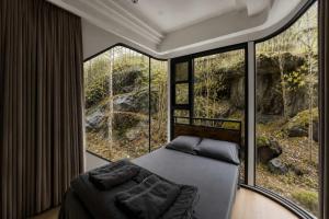 a bedroom with a bed in a room with large windows at #41 Space Capsule 1-bdr in Parry Sound