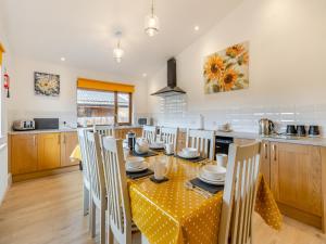 a kitchen and dining room with a table and chairs at Lime Lodge - Uk42547 in Llanwrthwl