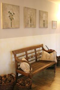 drewniana ławka siedząca w pokoju z kwiatami na ścianie w obiekcie Hotel Landhaus Garni w mieście Fockbek
