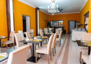 a dining room with yellow walls and tables and chairs at Albergo San Lorenzo in Grosseto
