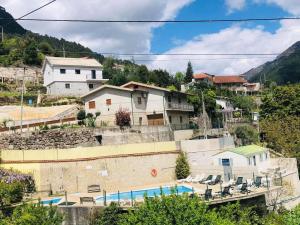 a resort with a swimming pool and houses at Residência Iris in Geres