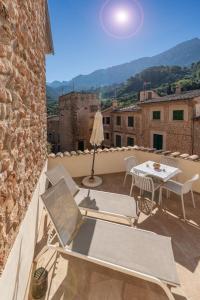 a patio with a table and chairs on a balcony at Can Mayol in Fornalutx