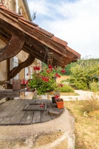 a wooden porch with flowers on a house at La Bastide de Sherlock in Troncens