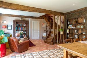 a living room with wooden walls and a staircase at La Bastide de Sherlock in Troncens