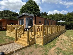 a cabin with a wooden deck and a house at Luxury Lodge in Beverley