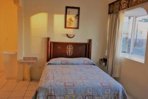 a bedroom with a bed and a window at Hotel Pekin in La Paz