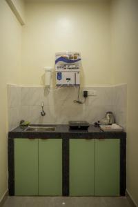eine Küche mit einer Arbeitsplatte und einer Mikrowelle in der Unterkunft coco haus in Canacona