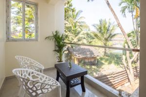 ein Esszimmer mit Tisch und Stühlen und einem Fenster in der Unterkunft coco haus in Canacona