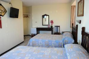 a bedroom with two beds and a mirror at Hotel Pekin in La Paz +10 photos