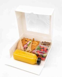 a white box filled with food and a yellow container at Hotel Barca Blu in Orselina